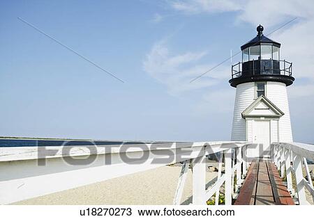 Stock Image - Lighthouse on sandy beach. Fotosearch