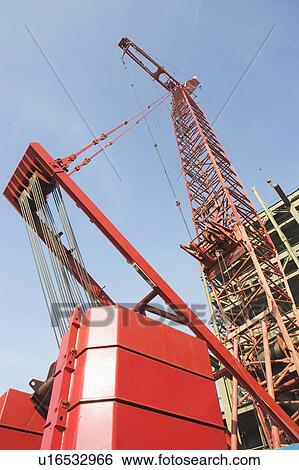 Stock Photograph - Low angle view of crane and building under construction. Fotosearch