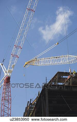 Stock Image - Low angle view of crane and construction frame. Fotosearch