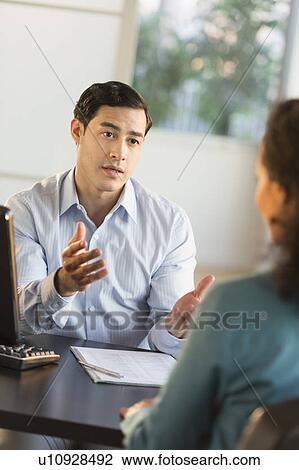 Man and woman talking at desk during job interview View Large Photo Image Stock Image - Man and woman talking at desk during job interview. Fotosearch