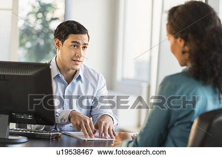 Man and woman talking at desk during job interview View Large Photo Image Stock Photo - Man and woman talking at desk during job interview. Fotosearch