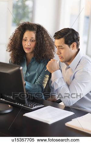 Man and woman working at desk in office View Large Photo Image Stock Photography - Man and woman working at desk in office. Fotosearch