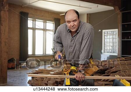 Stock Photo - Man cutting piece of plank. Fotosearch