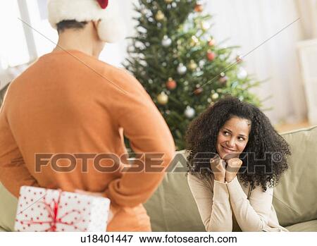 Man holding Christmas gift for woman View Large Photo Image Stock Photo - Man holding Christmas gift for woman. Fotosearch