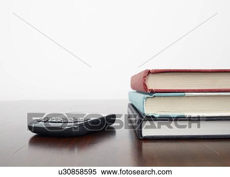 Mobile phone beside stack of books View Large Photo Image Stock Photography - Mobile phone beside stack of books. Fotosearch