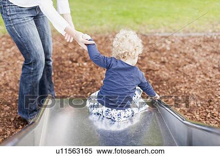 Stock Photography - Mother with daughter (2-3) on slide. Fotosearch