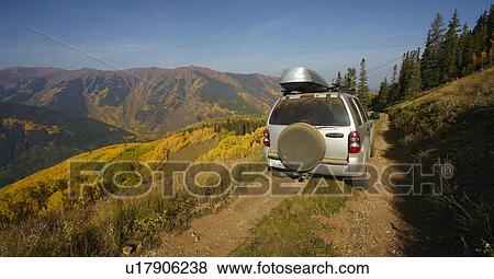 Mountain landscape with car on dirt road View Large Photo Image Stock Photo - Mountain landscape with car on dirt road. Fotosearch