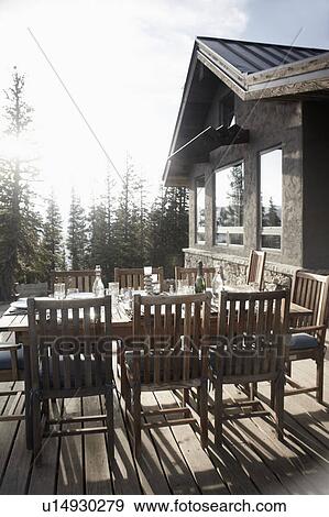 Stock Photo - Outdoor table and chairs in front of house. Fotosearch