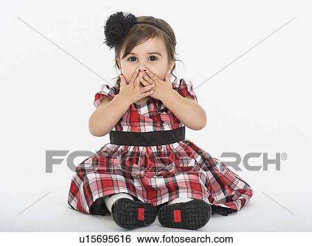 Portrait of Baby girl ( 6-11 months) wearing plaid dress with hands on mouth View Large Photo Image Stock Photograph - Portrait of Baby girl ( 6-11 months) wearing plaid dress with hands on mouth. Fotosearch