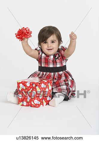 Stock Photography - Portrait of Baby girl ( 6-11 months) with gift box. Fotosearch