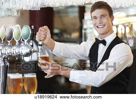 Picture - Portrait of bartender pouring beer. Fotosearch