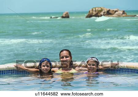 Stock Image - Portrait of family in swimming pool (8-9 years) (10-11 years). Fotosearch