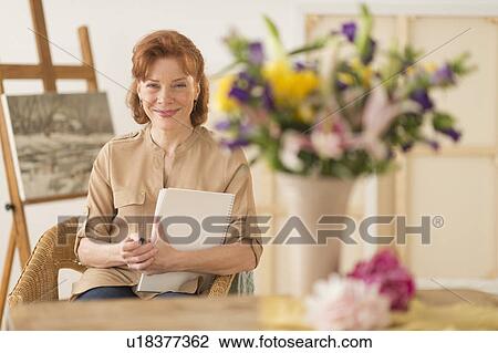 Stock Image - Portrait of female artist in studio. Fotosearch