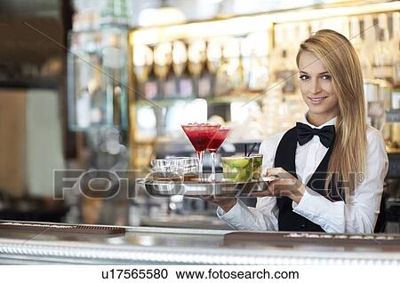 Portrait of female bartender holding tray with cocktails View Large Photo Image Stock Image - Portrait of female bartender holding tray with cocktails. Fotosearch