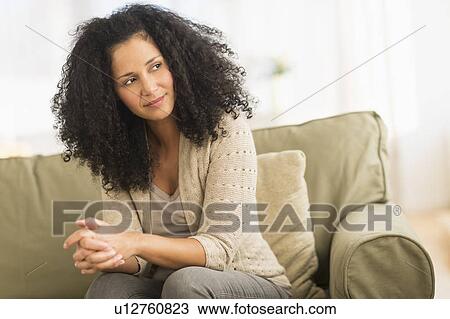 Portrait of mid adult woman sitting on sofa View Large Photo Image Stock Image - Portrait of mid adult woman sitting on sofa. Fotosearch