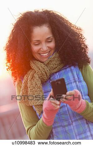 Portrait of mid adult woman using mobile phone at sunset View Large Photo Image Stock Image - Portrait of mid adult woman using mobile phone at sunset. Fotosearch