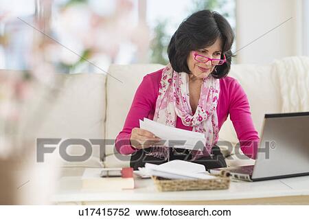 Portrait of senior woman sitting in living room with laptop View Large Photo Image Stock Image - Portrait of senior woman sitting in living room with laptop. Fotosearch