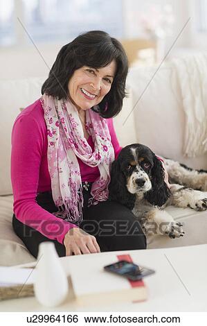 Portrait of senior woman sitting on sofa with her dog View Large Photo Image Stock Photograph - Portrait of senior woman sitting on sofa with her dog. Fotosearch