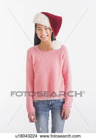 Picture - Portrait of teenage girl ( 16-17 years) wearing Santa hat. Fotosearch