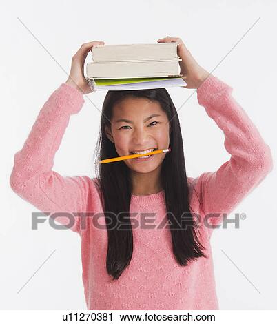Portrait of teenage girl ( 16-17 years) holding books on her head View Large Photo Image Stock Image - Portrait of teenage girl ( 16-17 years) holding books on her head . Fotosearch