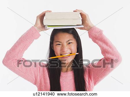 Portrait of teenage girl ( 16-17 years) holding books on her head View Large Photo Image Stock Image - Portrait of teenage girl ( 16-17 years) holding books on her head . Fotosearch