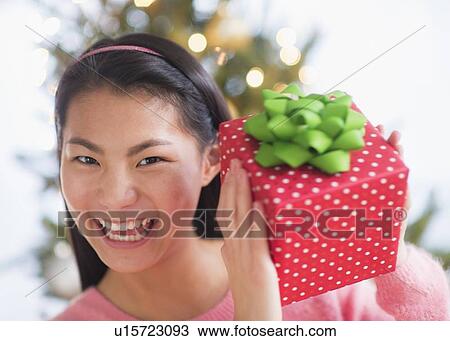 Portrait of teenage girl ( 16-17 years) holding Christmas gift View Large Photo Image Stock Image - Portrait of teenage girl ( 16-17 years) holding Christmas gift. Fotosearch
