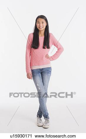Stock Image - Portrait of teenage girl ( 16-17 years) wearing jeans and pink sweater. Fotosearch