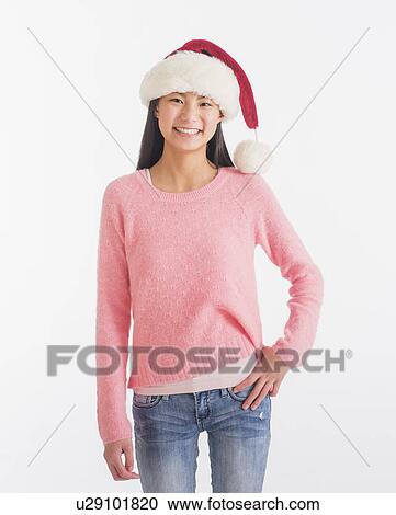 Portrait of teenage girl (16-17 years) wearing santa hat View Large Photo Image Stock Image - Portrait of teenage girl (16-17 years) wearing santa hat. Fotosearch
