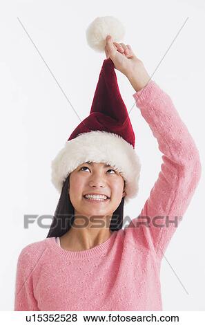 Portrait of teenage girl (16-17 years) wearing santa hat View Large Photo Image Stock Photo - Portrait of teenage girl (16-17 years) wearing santa hat. Fotosearch