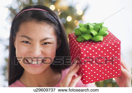 Portrait of teenage girl ( 16-17 years) holding Christmas gift View Large Photo Image Stock Photo - Portrait of teenage girl ( 16-17 years) holding Christmas gift. Fotosearch