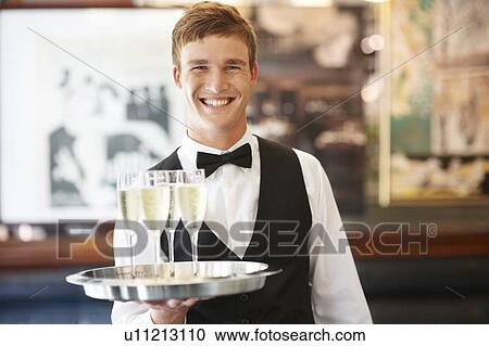 Portrait of waiter holding champagne flutes on tray View Large Photo Image Stock Image - Portrait of waiter holding champagne flutes on tray. Fotosearch