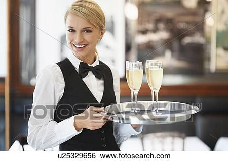 Portrait of waitress holding champagne flutes on tray View Large Photo Image Stock Photograph - Portrait of waitress holding champagne flutes on tray. Fotosearch