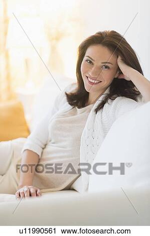 Portrait of woman sitting on sofa View Large Photo Image Stock Image - Portrait of woman sitting on sofa. Fotosearch