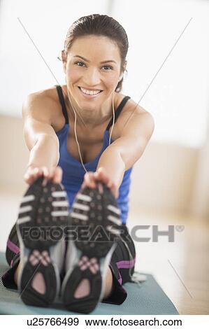 Stock Photo - Portrait of woman stretching in gym. Fotosearch