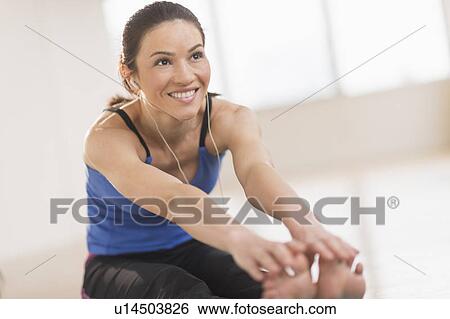 Stock Photograph - Portrait of woman stretching in gym. Fotosearch