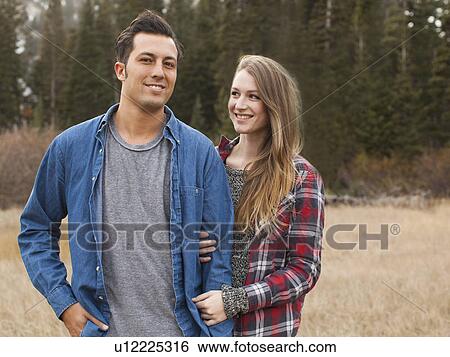 Stock Photograph - Portrait of young couple in non-urban scene. Fotosearch