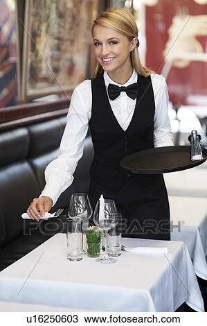 Portrait of young waitress setting table View Large Photo Image Stock Image - Portrait of young waitress setting table. Fotosearch