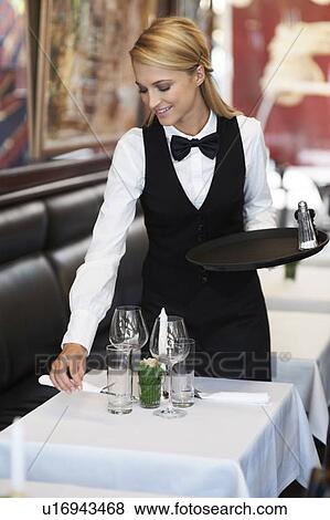 Portrait of young waitress setting table View Large Photo Image Stock Photo - Portrait of young waitress setting table. Fotosearch