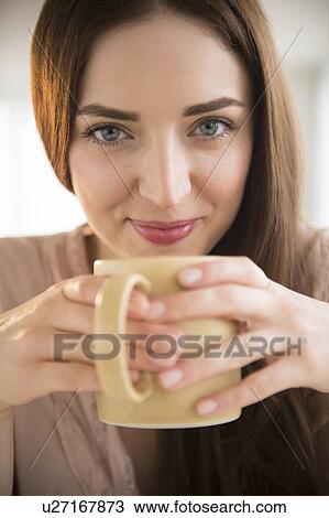 Portrait of young woman holding coffee cup View Large Photo Image Stock Image - Portrait of young woman holding coffee cup. Fotosearch