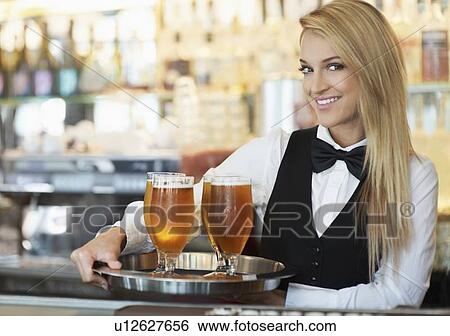 Portrait of young woman holding tray with beer glasses View Large Photo Image Stock Photograph - Portrait of young woman holding tray with beer glasses. Fotosearch