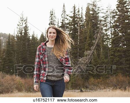 Stock Photo - Portrait of young woman walking in non-urban scene. Fotosearch
