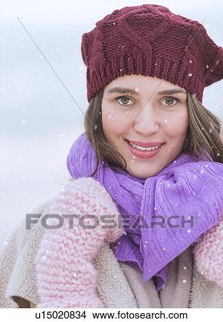 Picture - Portrait of young woman wearing knit hat, gloves and scarf. Fotosearch