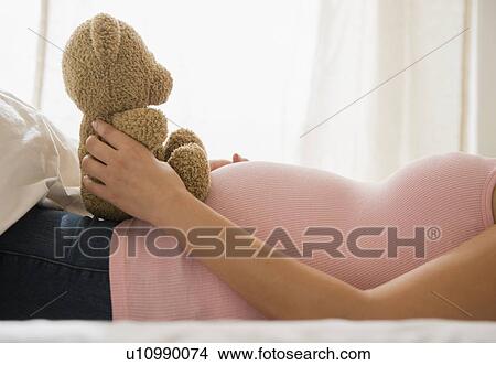 Pregnant woman holding teddy bear View Large Photo Image Picture - Pregnant woman holding teddy bear. Fotosearch