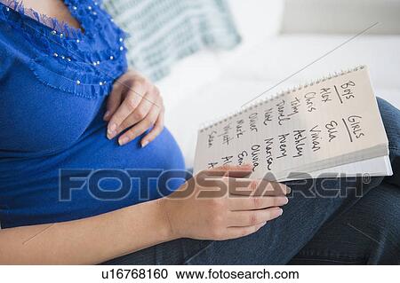 Stock Image - Pregnant woman with names list. Fotosearch