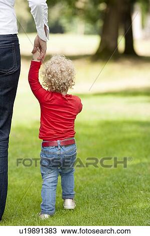 Rear view of girl (2-3) walking with her mother View Large Photo Image Stock Image - Rear view of girl (2-3) walking with her mother. Fotosearch