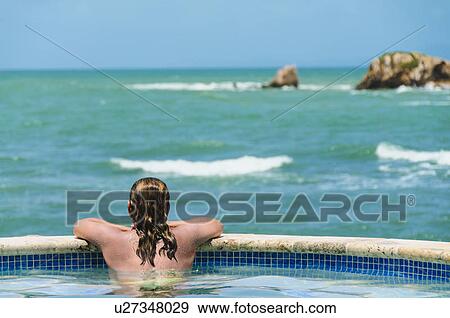 Stock Photo - Rear view of mature woman looking at sea. Fotosearch