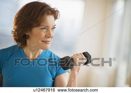 Stock Photograph - Senior woman lifting weights. Fotosearch