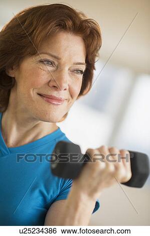 Senior woman lifting weights View Large Photo Image Stock Photograph - Senior woman lifting weights. Fotosearch