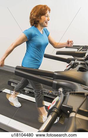 Stock Image - Senior woman on treadmill. Fotosearch