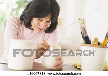 Senior woman painting handmade pottery View Large Photo Image Stock Image - Senior woman painting handmade pottery. Fotosearch